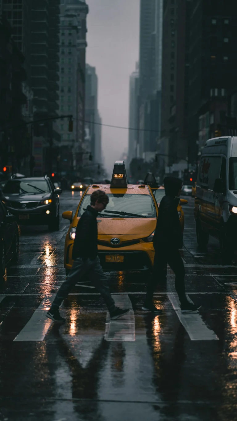 Busy New York City crosswalk with people walking, yellow taxi in background, urban street photography, high contrast, cinematic lighting